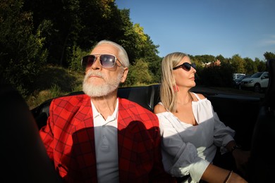 Photo of Senior couple enjoying cabriolet ride in city, wide angle lens