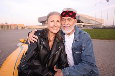 Photo of Stylish senior couple near modern cabriolet outdoors