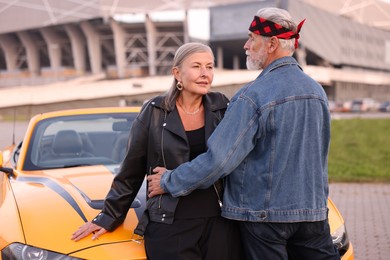 Photo of Stylish senior couple near modern cabriolet outdoors