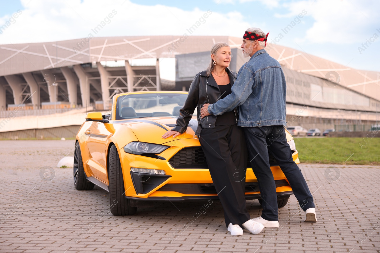 Stylish senior couple near modern cabriolet outdoors Photo of Stylish senior couple near modern cabriolet outdoors