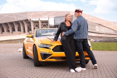 Photo of Stylish senior couple near modern cabriolet outdoors