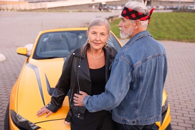 Photo of Stylish senior couple near modern cabriolet outdoors