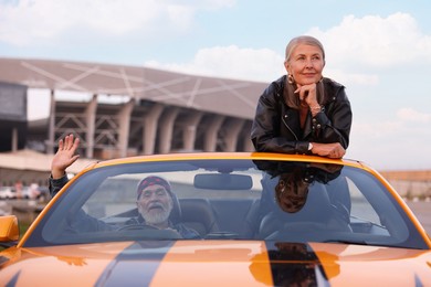 Photo of Senior couple enjoying cabriolet ride in city