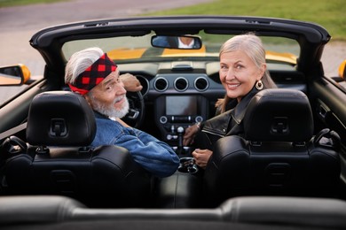 Photo of Stylish senior couple in modern cabriolet outdoors
