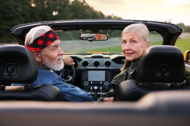 Photo of Stylish senior couple in modern cabriolet outdoors
