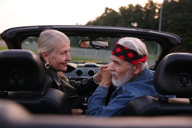 Photo of Stylish senior couple in modern cabriolet outdoors