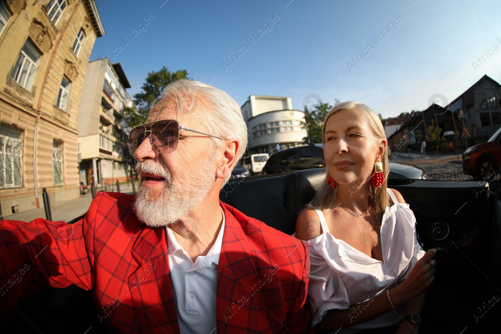 Senior couple enjoying cabriolet ride in city, wide angle lens Photo of Senior couple enjoying cabriolet ride in city, wide angle lens