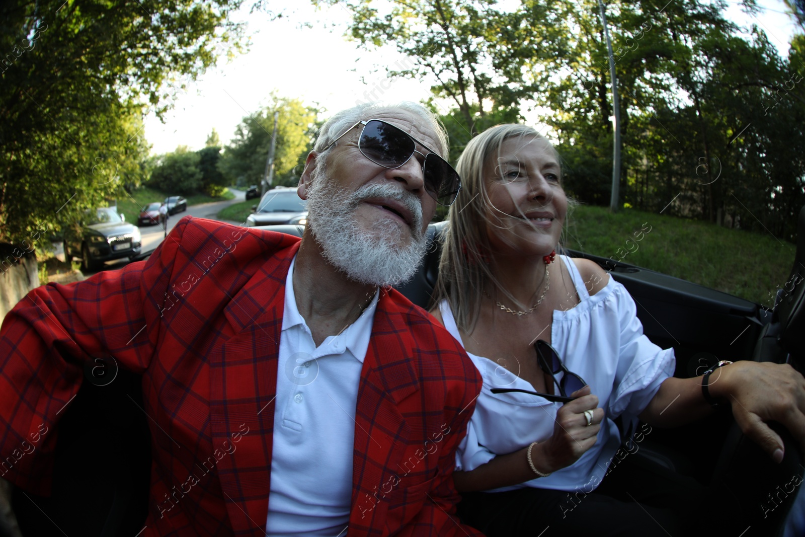 Senior couple enjoying cabriolet ride in city, wide angle lens Photo of Senior couple enjoying cabriolet ride in city, wide angle lens