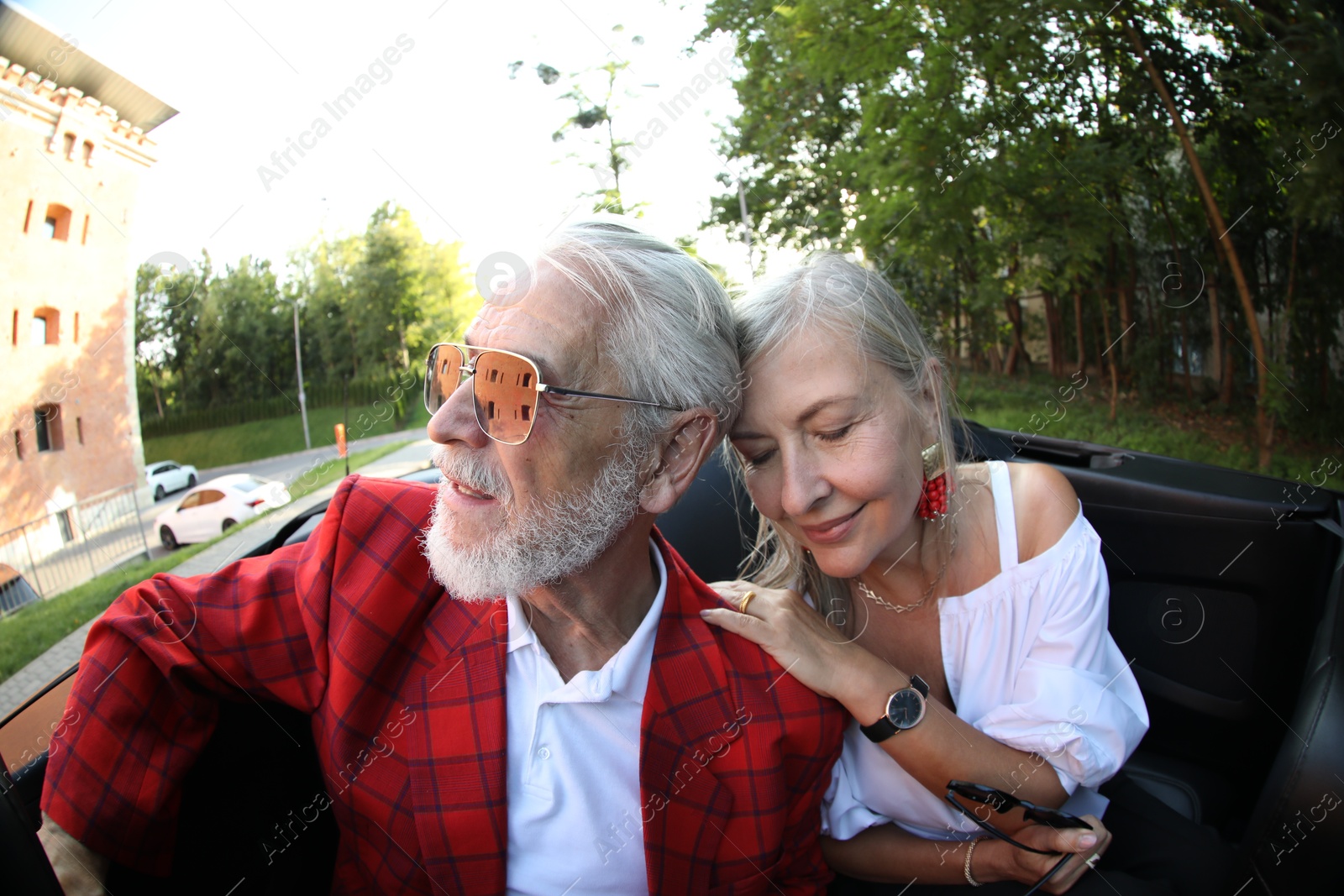 Senior couple enjoying cabriolet ride in city, wide angle lens Photo of Senior couple enjoying cabriolet ride in city, wide angle lens