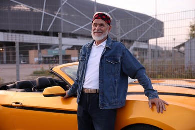Photo of Stylish senior man near modern cabriolet outdoors