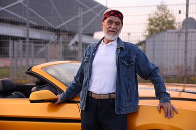 Photo of Stylish senior man near modern cabriolet outdoors