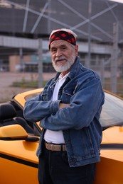 Photo of Stylish senior man near modern cabriolet outdoors