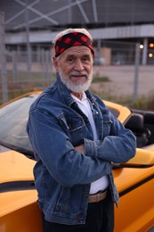 Photo of Stylish senior man near modern cabriolet outdoors