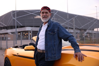 Photo of Stylish senior man near modern cabriolet outdoors