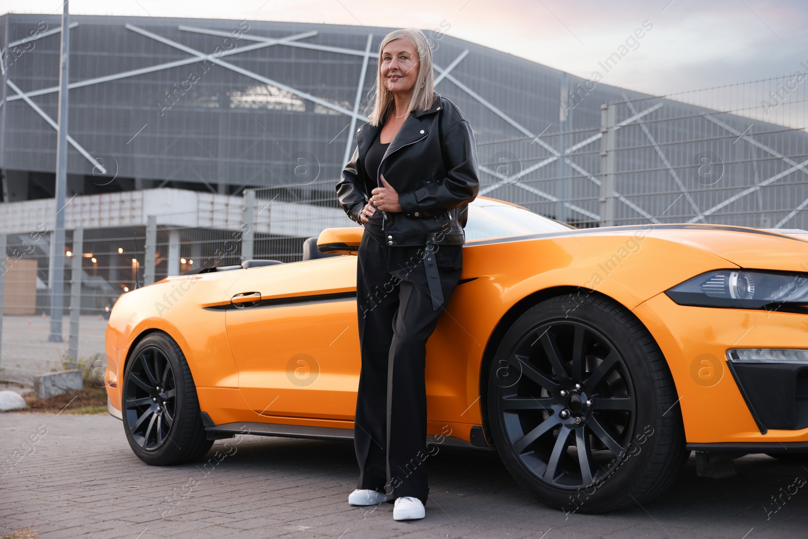 Photo of Stylish senior woman near modern cabriolet outdoors