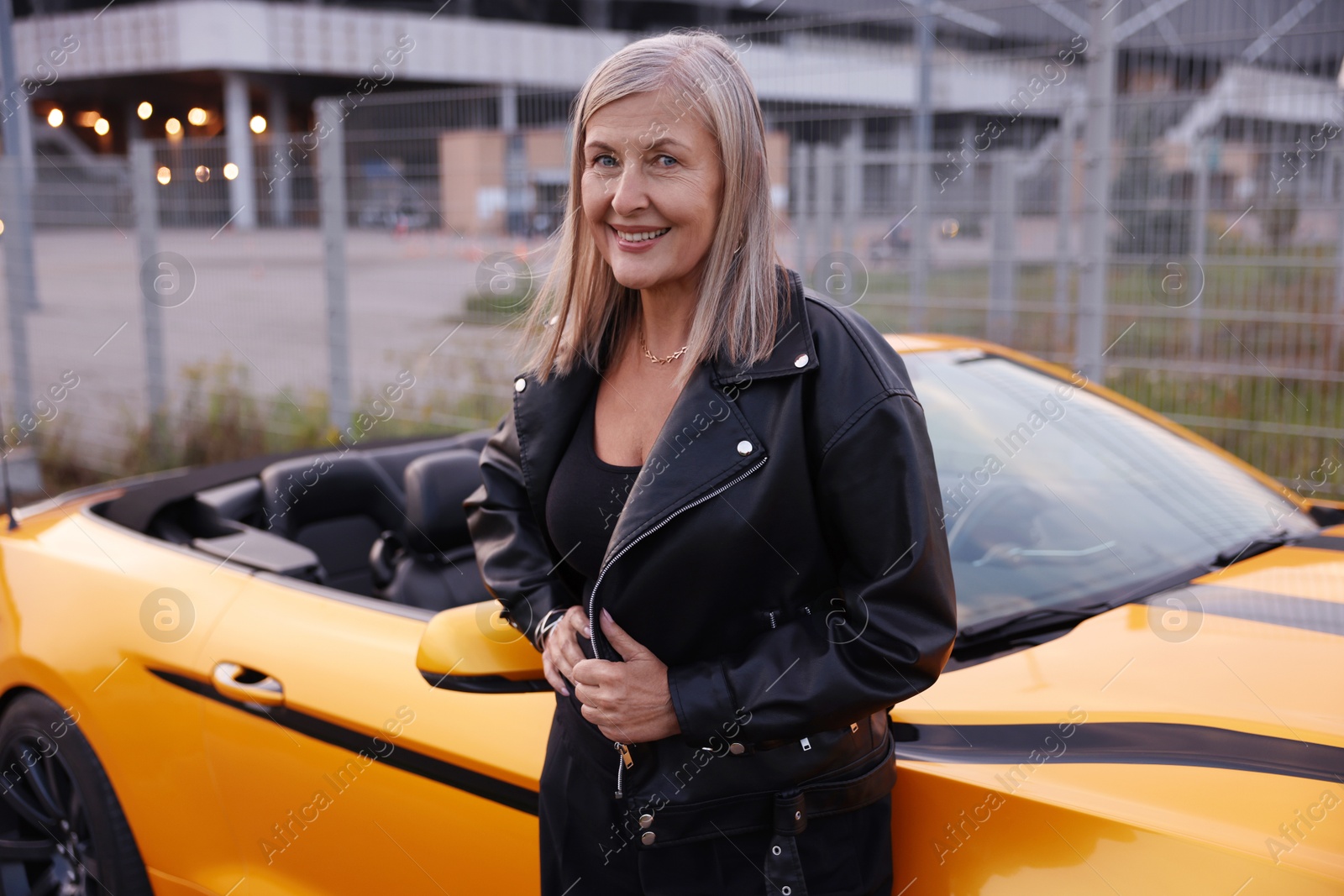 Photo of Stylish senior woman near modern cabriolet outdoors