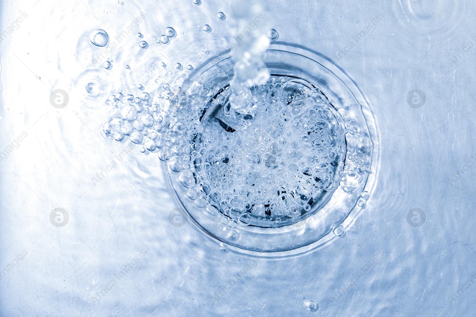 Photo of Water going down sink drain, top view