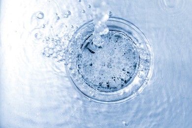 Photo of Water going down sink drain, top view