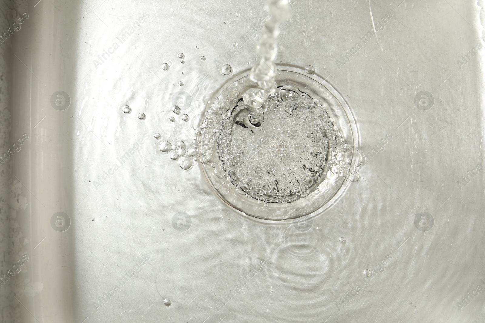 Water going down sink drain, top view Photo of Water going down sink drain, top view