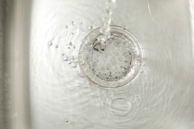 Photo of Water going down sink drain, top view