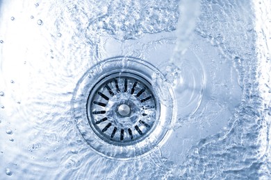 Photo of Water going down sink drain, top view
