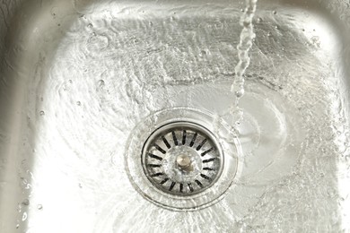 Photo of Water going down sink drain, closeup view