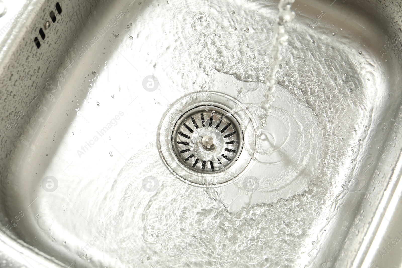 Water going down sink drain, above view Photo of Water going down sink drain, above view