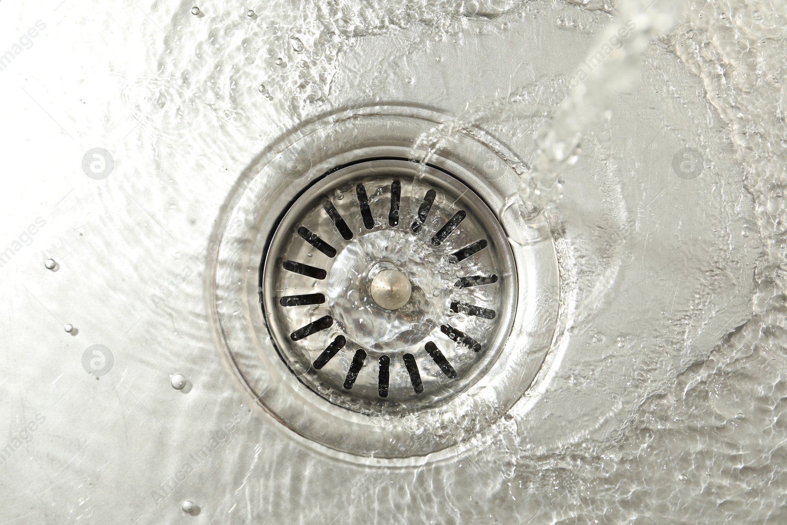 Water going down sink drain, top view Photo of Water going down sink drain, top view