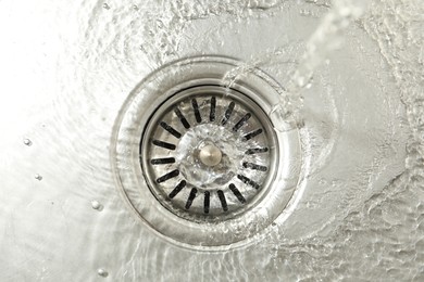 Photo of Water going down sink drain, top view
