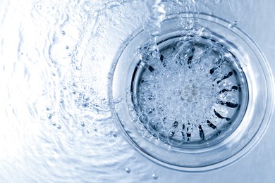 Photo of Water going down sink drain, top view