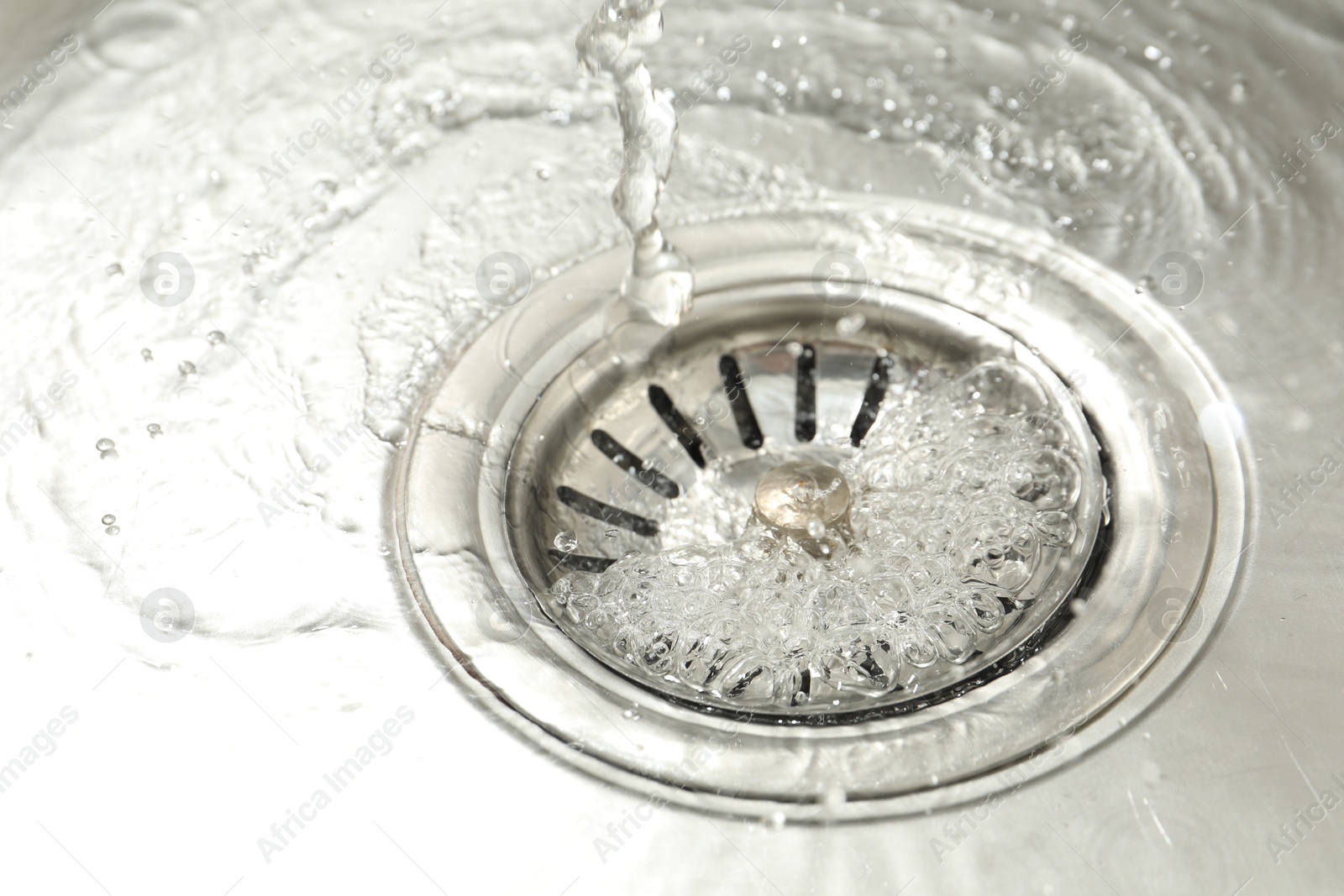 Photo of Water going down sink drain, closeup view