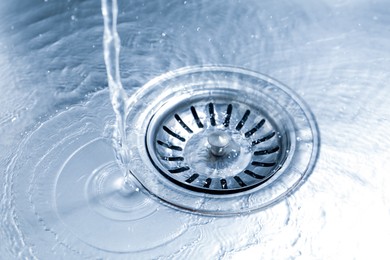 Photo of Water going down sink drain, closeup view