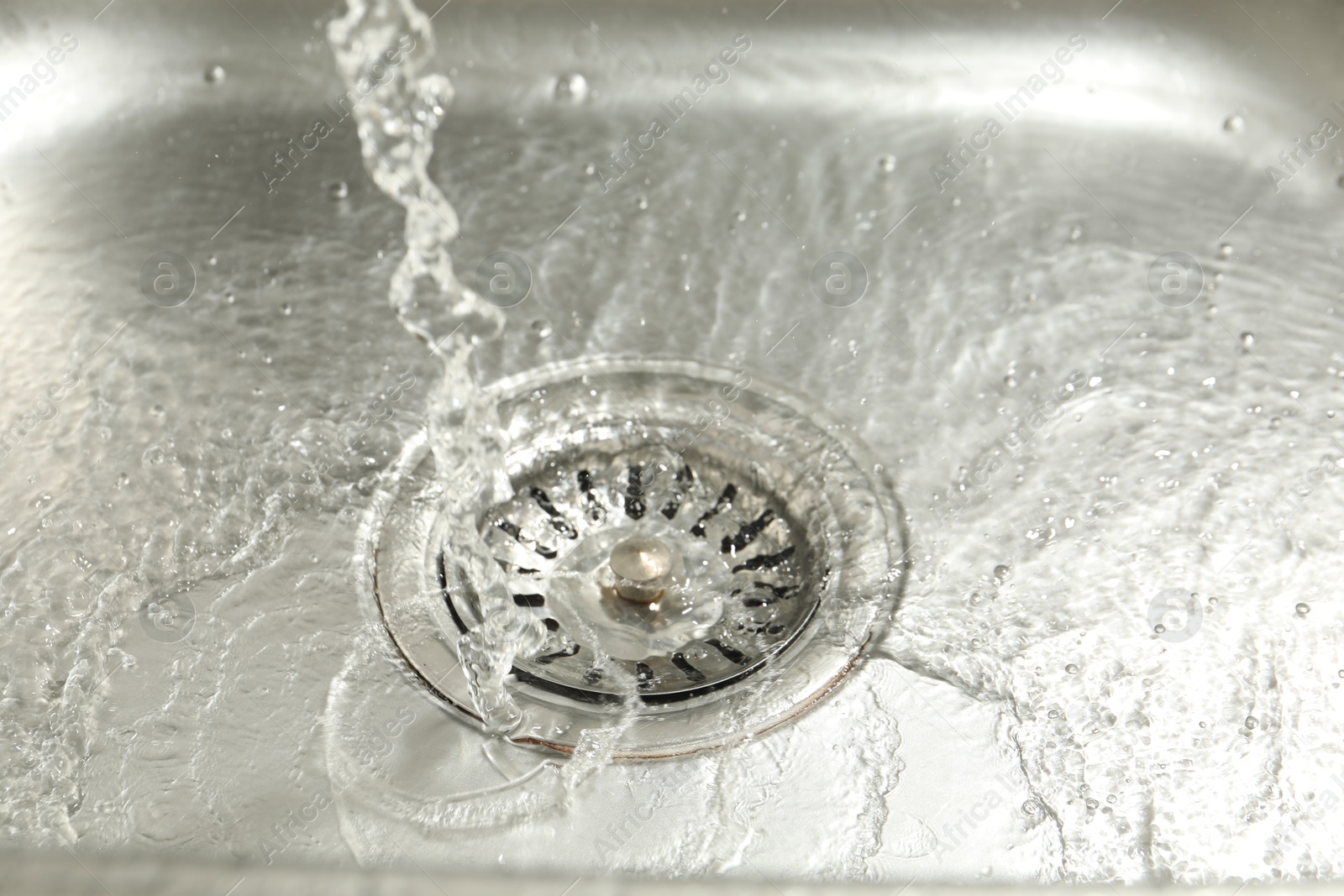 Photo of Water going down sink drain, closeup view