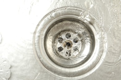 Photo of Water going down sink drain, top view