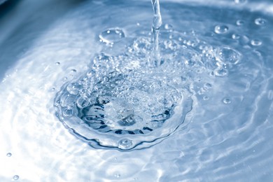 Photo of Water going down sink drain, closeup view