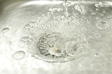 Photo of Water going down sink drain, closeup view