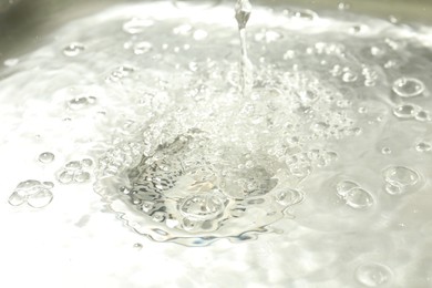 Photo of Water going down sink drain, closeup view
