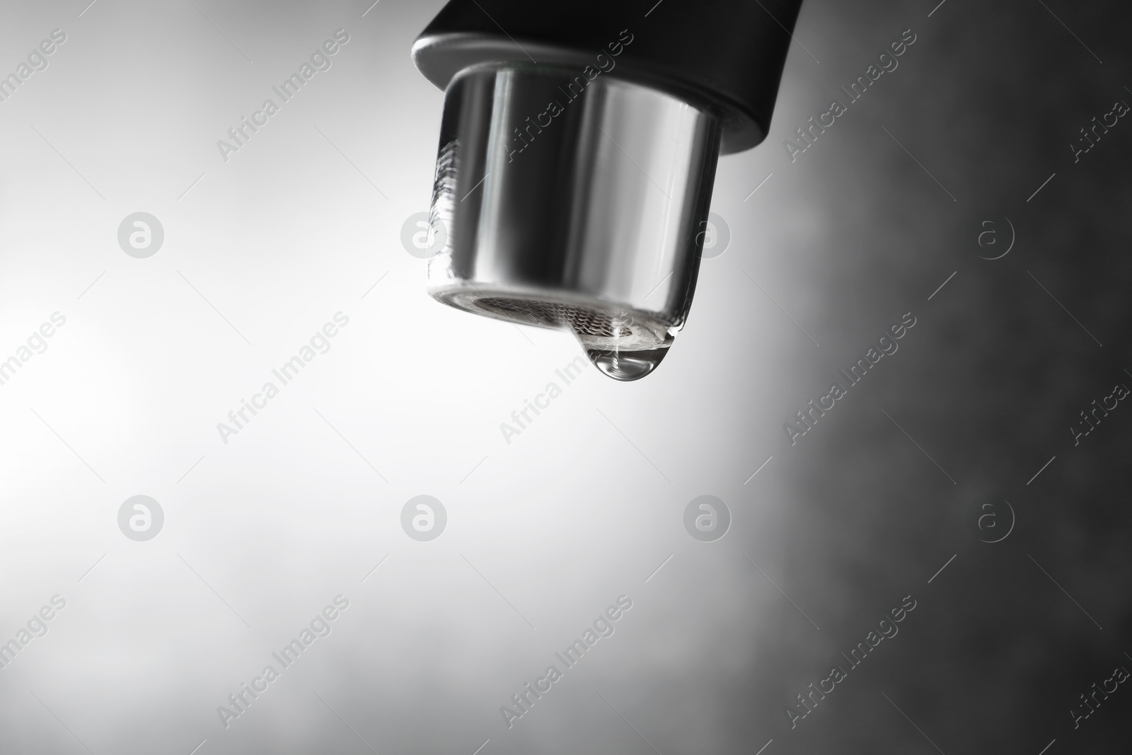 Water dripping down from faucet on grey background, closeup. Space for text Photo of Water dripping down from faucet on grey background, closeup. Space for text