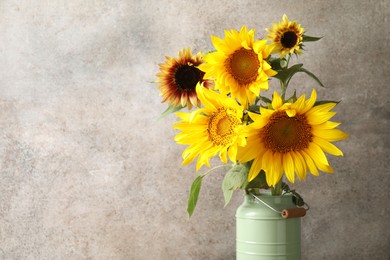 Photo of Beautiful sunflowers in can used as vase on grey background, closeup. Space for text