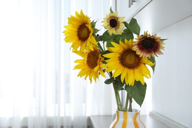 Photo of Beautiful sunflowers in jug on table indoors, closeup. Space for text
