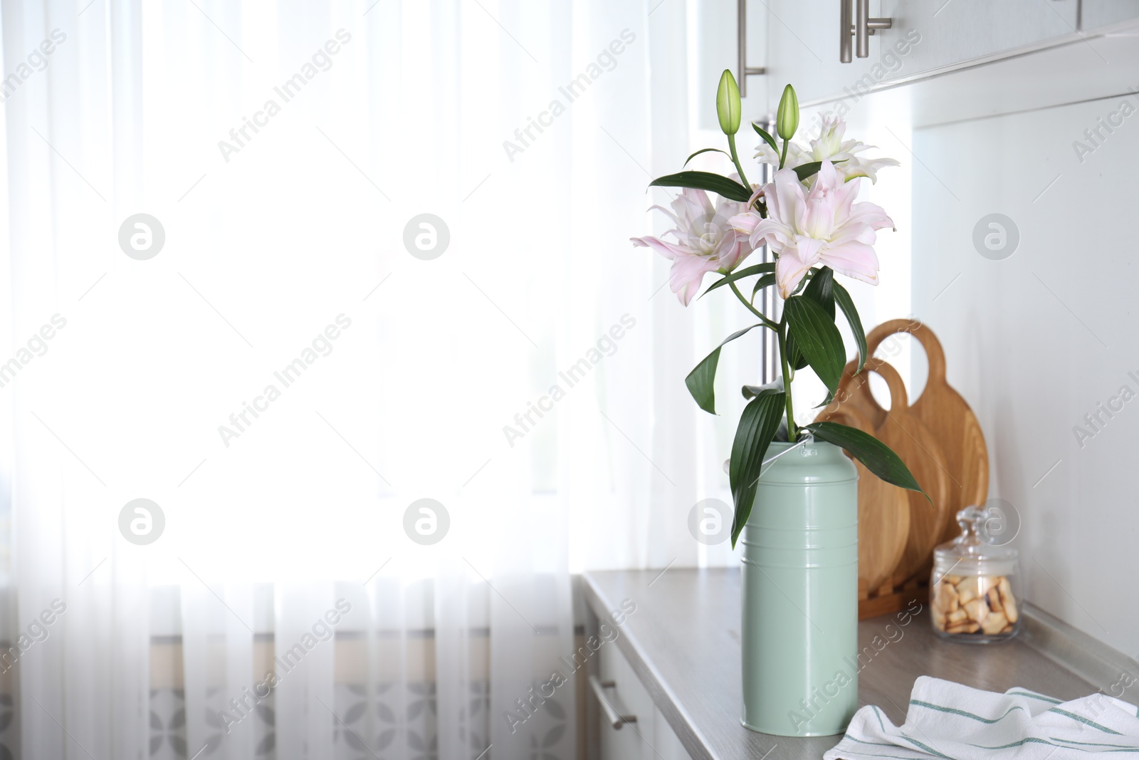 Beautiful lily flowers in can used as vase on wooden cabinet indoors, space for text Photo of Beautiful lily flowers in can used as vase on wooden cabinet indoors, space for text