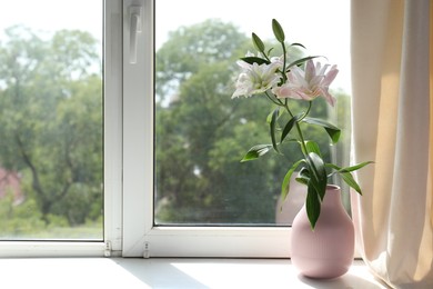 Photo of Beautiful lily flowers in vase near window indoors, space for text