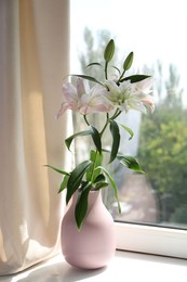 Photo of Beautiful lily flowers in vase near window indoors