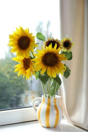 Photo of Beautiful sunflowers in jug near window indoors