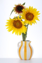Photo of Beautiful sunflowers in jug on white background