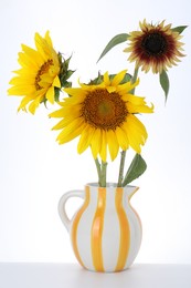 Photo of Beautiful sunflowers in jug on white background