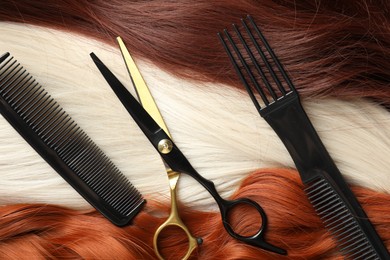 Photo of Strands of different beautiful hair, combs and hairdresser's scissors, top view