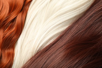 Photo of Strands of different beautiful hair as background, top view