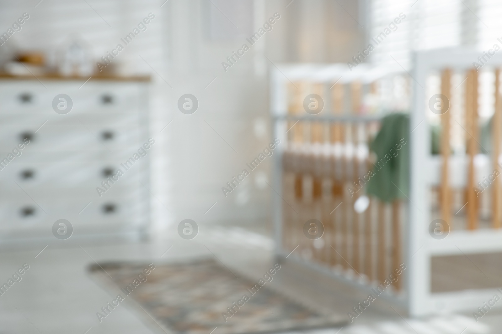 Photo of Blurred view of baby's room with stylish crib