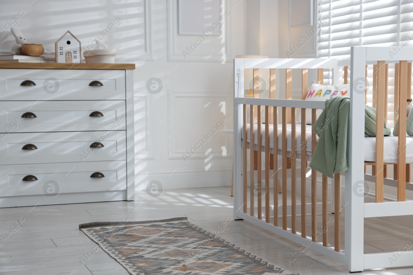 Stylish baby's room with crib and chest of drawers. Interior design Photo of Stylish baby's room with crib and chest of drawers. Interior design